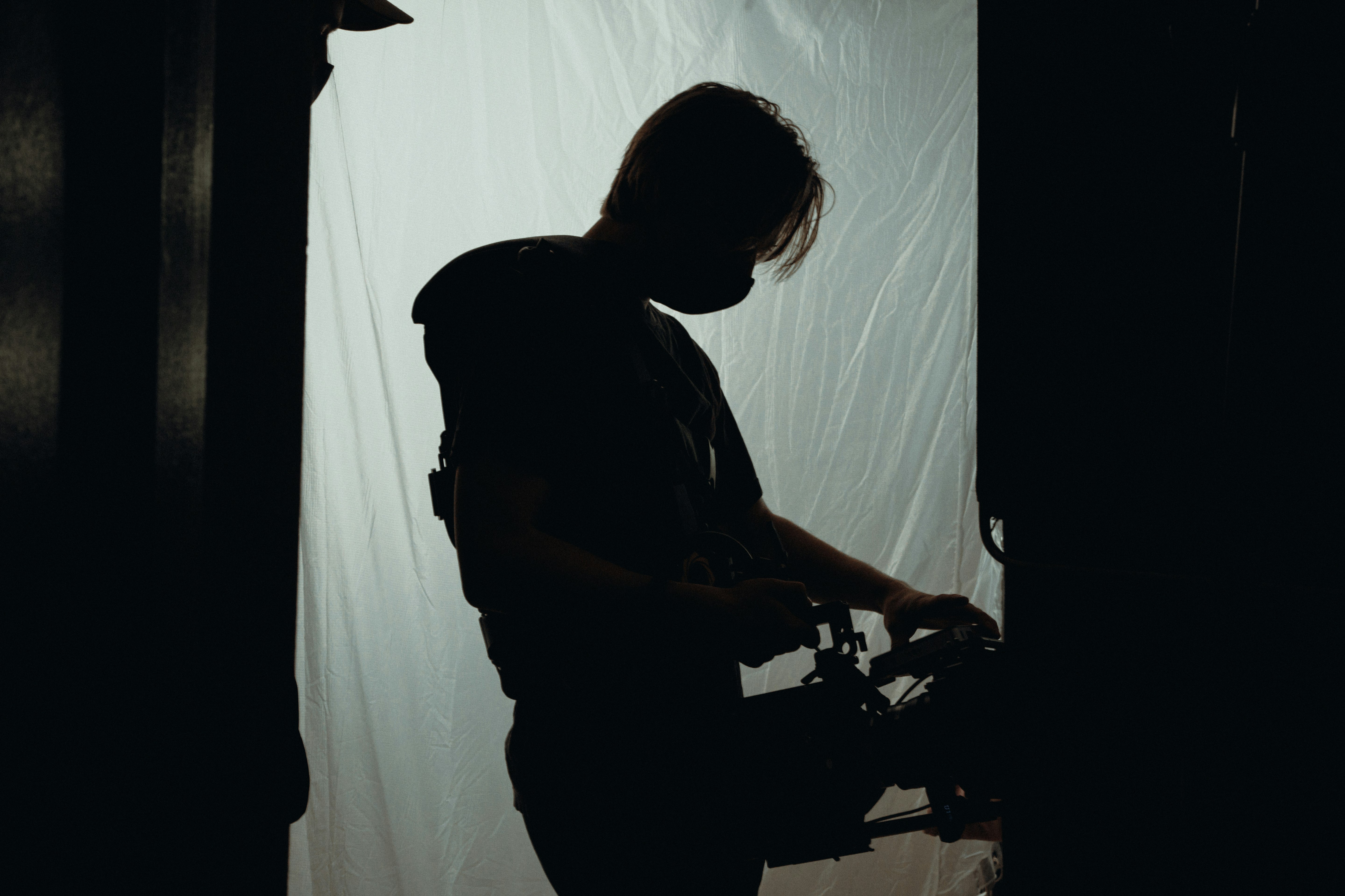 man in black t-shirt standing near white curtain